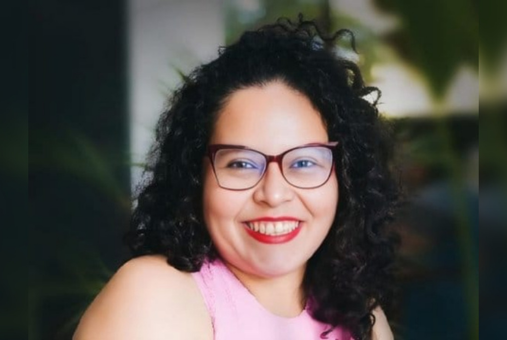 Woman in pink shirt and wearing glasses